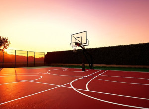 Campo da basket vuoto con canestro al tramonto, illuminazione cinematografica, 8k, iperrealistico.